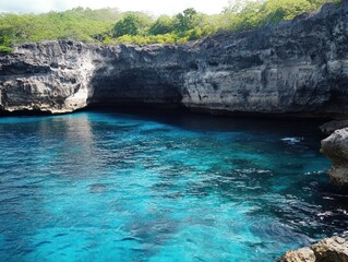 Obraz premium Turquoise blue water in a cove surrounded by rocky cliffs and lush green vegetation