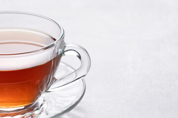 Cup of tea on white tablecloth. Closeup.