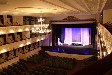 Theatre interior with stage, rows of comfortable seats and beautiful chandelier