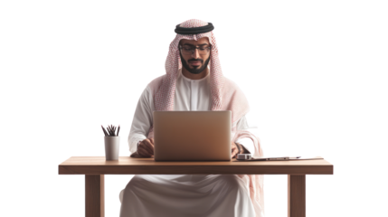 A focused professional man in traditional attire working on a laptop at a wooden desk with stationery. Perfect for business and technology themes.