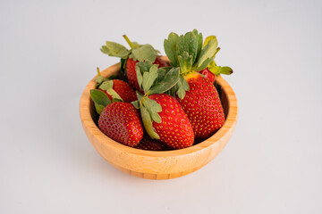 strawberry in wood plate isolated on white background