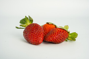 Fresh, ripe strawberry. Whole strawberry with leaf isolated on white background. Perfect retouched strawberry, not AI.