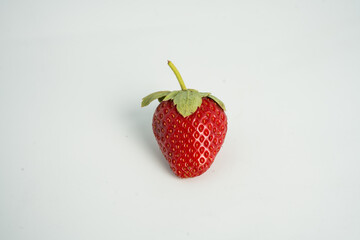 Fresh, ripe strawberry. Whole strawberry with leaf isolated on white background. Perfect retouched strawberry, not AI.