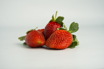 Fresh, ripe strawberry. Whole strawberry with leaf isolated on white background. Perfect retouched strawberry, not AI.