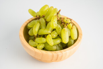 Grapes in a wooden plate on a white background isolated