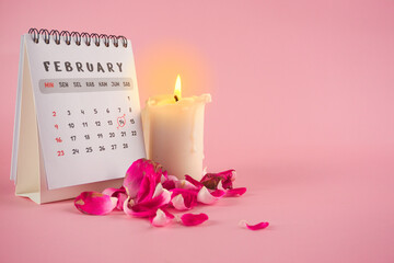 Valentine's Day Calendar With White Candle and Rose Petals on Pink Background