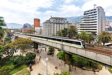 Medellin skyline with Metro de Medellín train at Plaza Botero in Medellin, Colombia