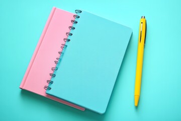 Pastel notebooks, pen, turquoise background; planning, studying