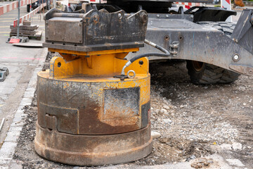 Accessories to be mounted on an excavator, standing on a construction site.
