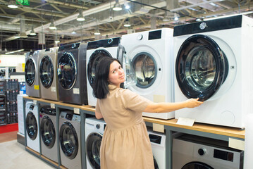 woman choosing a washing machine in a home appliance store