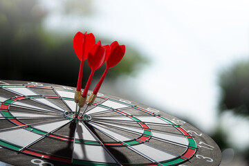 three red darts on target with blur background