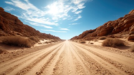 A mesmerizing view of a sandy desert road, flanked by rocky formations under a bright sky, depicting the vastness and beauty of nature's rugged landscapes.