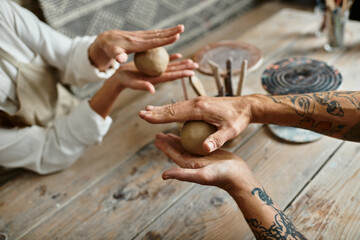 A mature couple enjoys shaping clay while taking a pottery class, sharing quality time.
