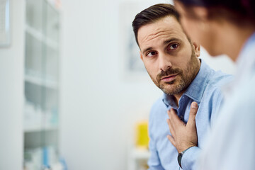 Concerned Man Consulting with Doctor in Bright Medical Office Environment