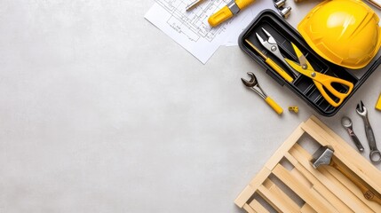 Tools including screwdriver bits and wood dowels are organized in a toolkit, accompanied by construction blueprints on a flat surface