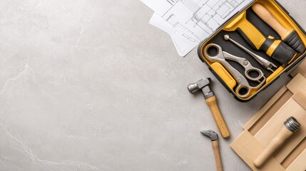 Tools including screwdriver bits and wood dowels are organized in a toolkit, accompanied by construction blueprints on a flat surface