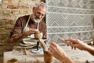 Mature couple bonds over clay in pottery class, enhancing creativity and connection.