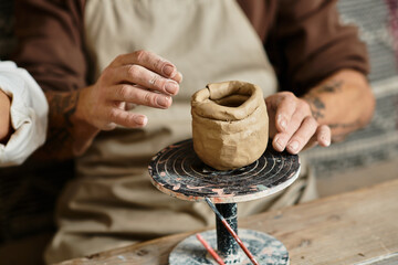 A middle-aged couple enjoys quality time shaping clay in a pottery class.