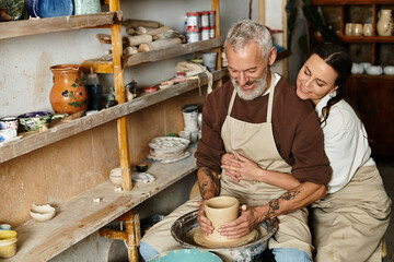 A mature couple enjoys quality time shaping clay in a pottery class, creating cherished memories.