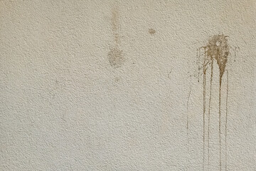 Textured wall with stains and markings in an outdoor setting under natural light