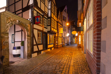 Night view of a narrow cobblestone street in the Schnoor district of Bremen, Germany