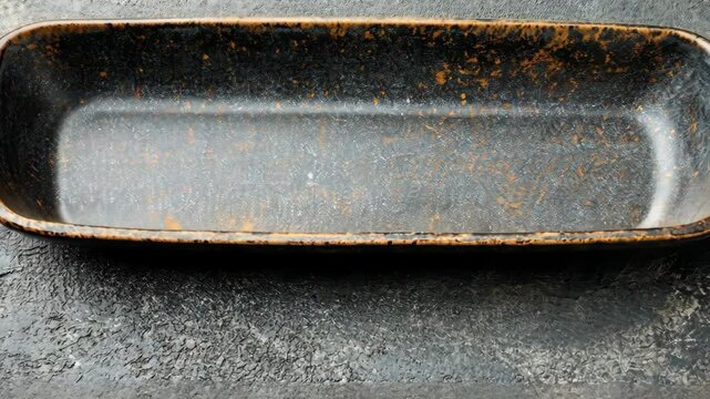 Rectangular ceramic dish with a rustic finish on a textured background
