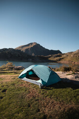 Scenic view of a camping tent pitched near a tranquil mountain lake in the pyrenees, offering a peaceful retreat amidst nature © Larraend Fotografía
