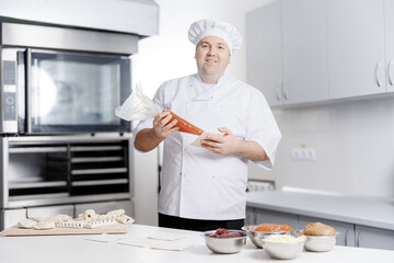 Male caucasian adult pastry chef demonstrates puff pastry production in confectionery food industry