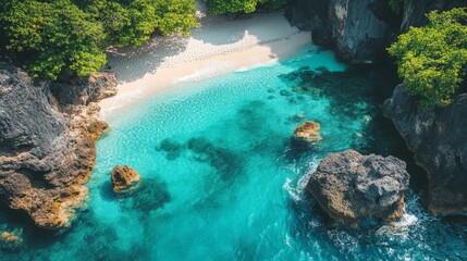 Aerial view of a hidden cove with crystal clear turquoise waters and a sandy beach surrounded by rocky cliffs and lush green vegetation