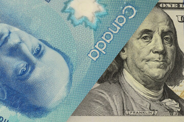 Portrait of the US President on the dollar bill peeks out from underneath the Canadian dollar bill. Currency market. Finance concept