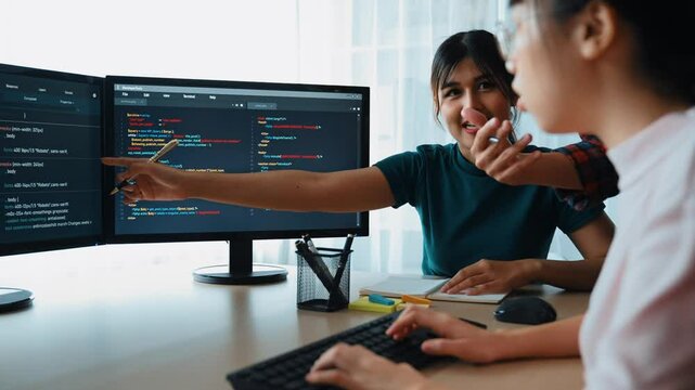 Slow motion back end software developer engineer for computer programming working together on debugging writing computing code, solving complex algorithms display on monitor in office. Burgeoning