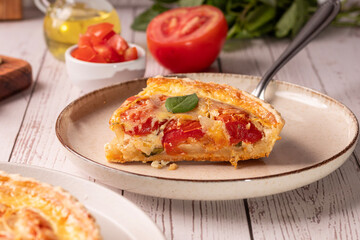 Quiche de tomate com queijo e manjericão, elementos como azeite, tomate e manjericão ao redor da cena