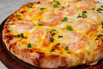 four cheese pizza with shrimp and fresh microgreens, served on a wooden board, homemade, no people,