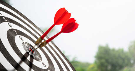 two red dart on target with sky and tree