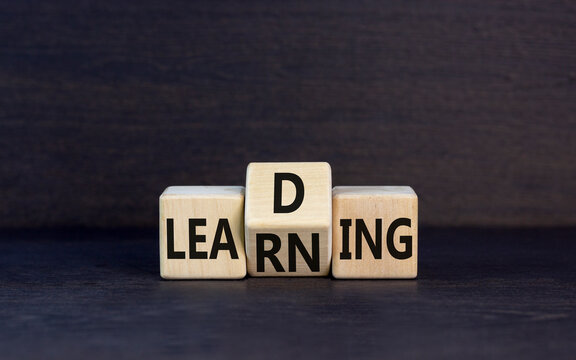 Learning or leading symbol. Concept words Learning Leading on wooden block. Beautiful black table black background. Business learning or leading concept. Copy space.