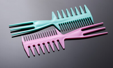 Pink and blue plastic combs on black background