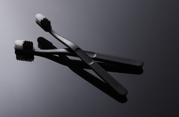Two Plastic Toothbrushes On Black Background