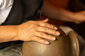 Woman's hands creating traditional pottery in Oaxaca, Mexico