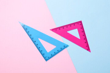 Rulers triangles on pink blue background. Top view