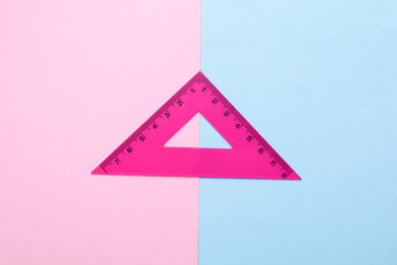 Ruler triangle on pink blue background. Top view