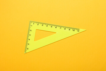 Ruler triangle on yellow background. Top view