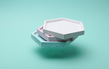 Plaster hexagon trays floating on a blue background