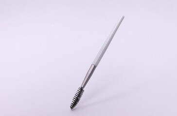 Gray makeup brush floating on white background