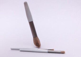 Gray makeup brush floating on white background