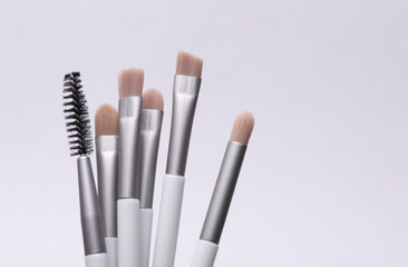 Set of makeup brushes on a gray background