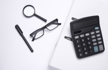 Black classic calculator with stationery on white background. Office accessories. Top view. Flat lay. Working space
