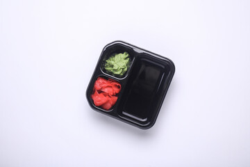 Tray with ginger, wasabi and soy sauce on white background