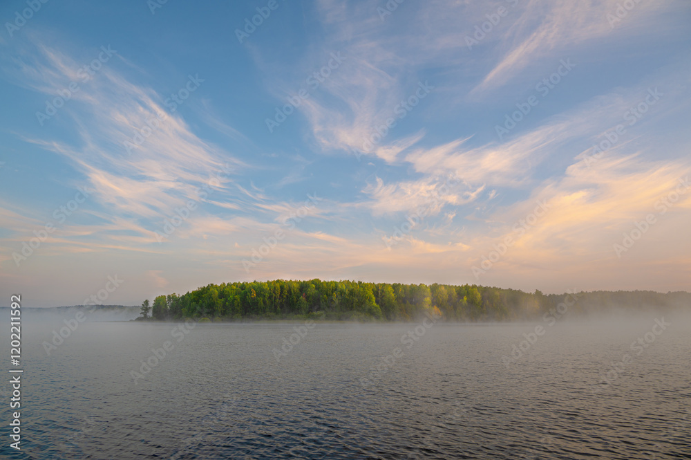 Wall mural a beautiful autumn morning landscape with a misty riverbank and a blue sky with pink clouds.