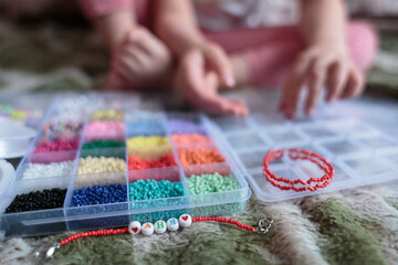 Obraz premium Multi-colored beads close-up against the background of a child, educational game, child development.