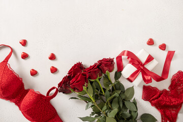 Valentine's day frame with red lace bustier underwear, candy sweets and red roses on white...